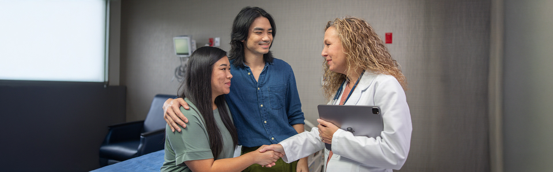 couple talking to physician, shaking hands