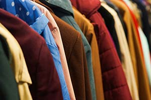 different colored coats on a rack